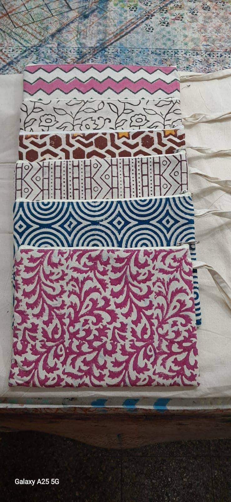 A stack of block-printed zip pouches showing chevron, floral and spiral prints
