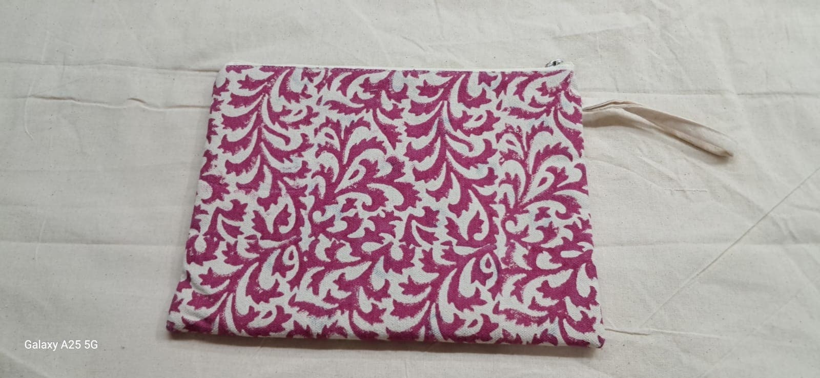 Zip pouch in a magenta fern block print with a cotton zip pull