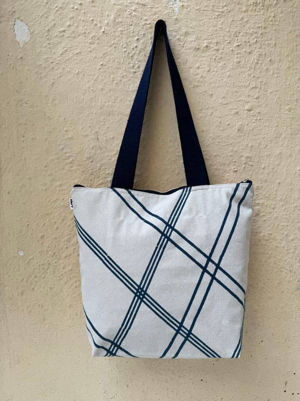 Cotton tote block-printed with a navy diagonal windowpane grid, navy handles