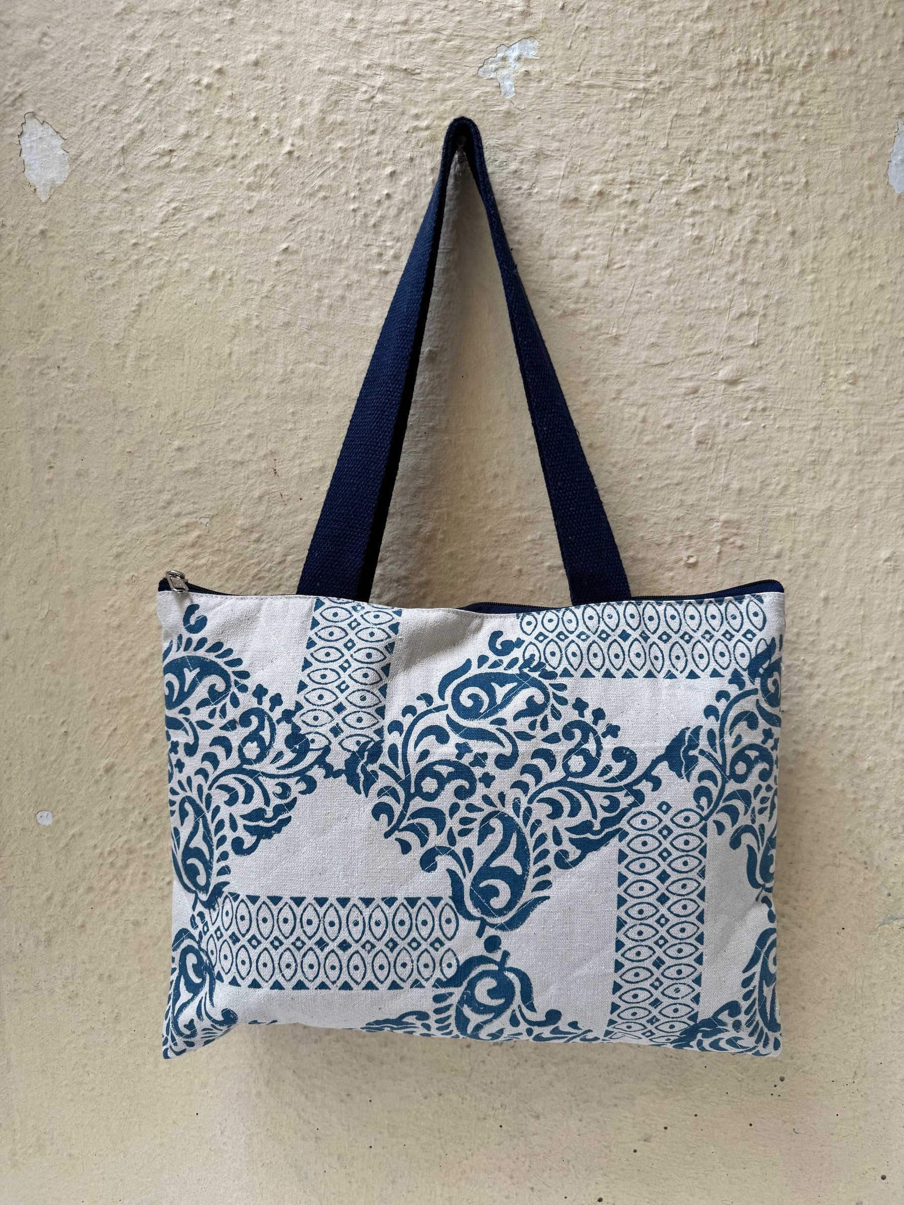 Quilted zip tote in dense indigo paisley and lattice patchwork prints with navy handles