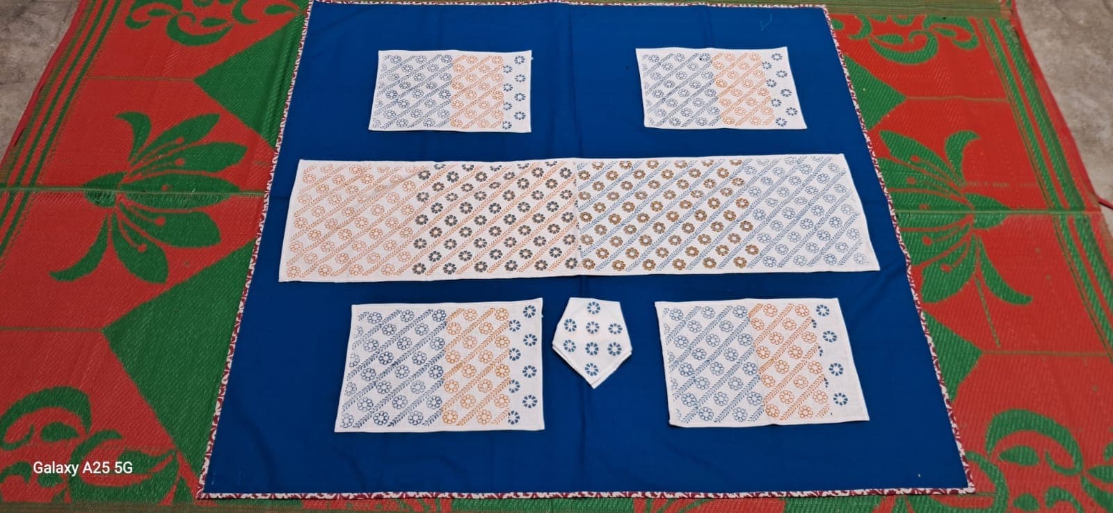 Table linen set with dotted block prints on cream: runner, placemats and a folded napkin fan