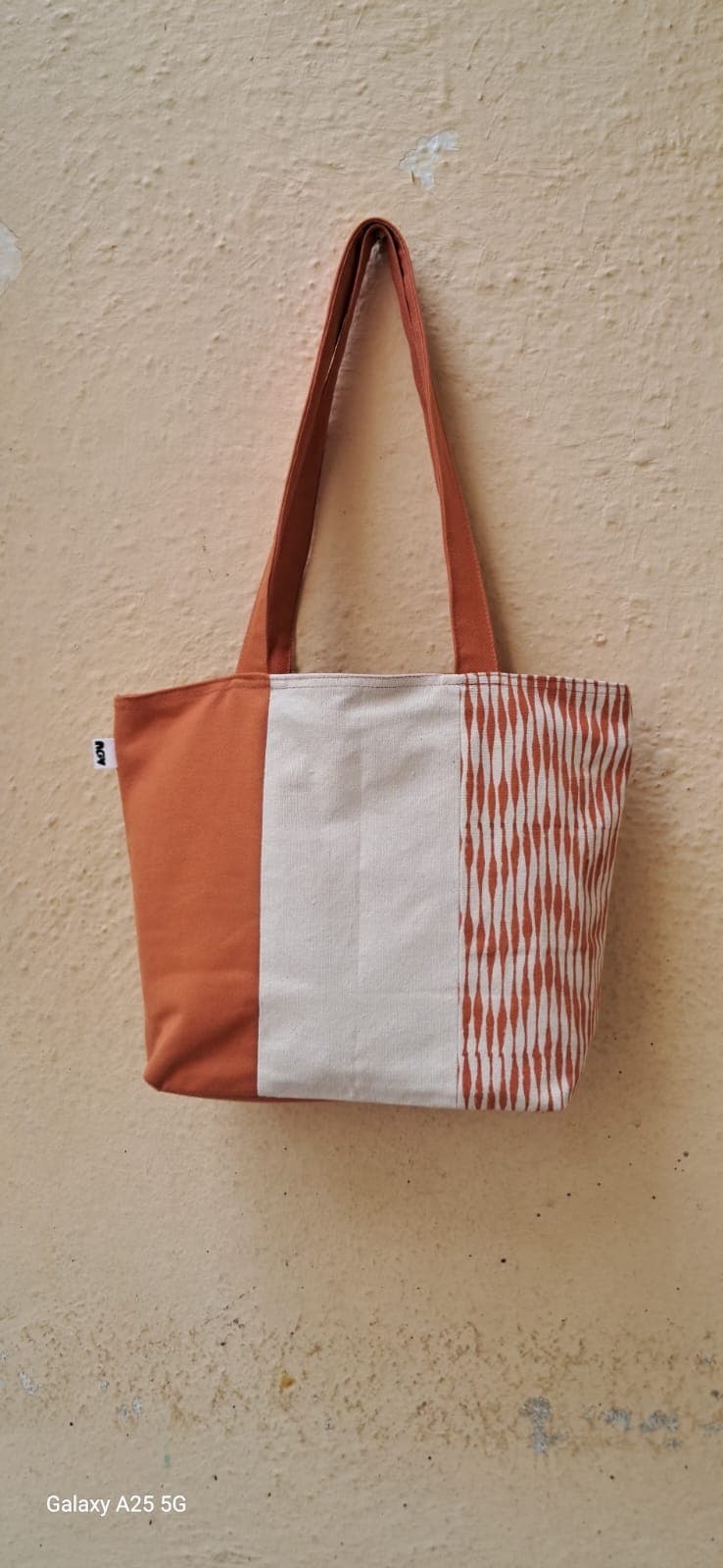 Small colour-block tote in rust and cream with a woven chevron stripe panel