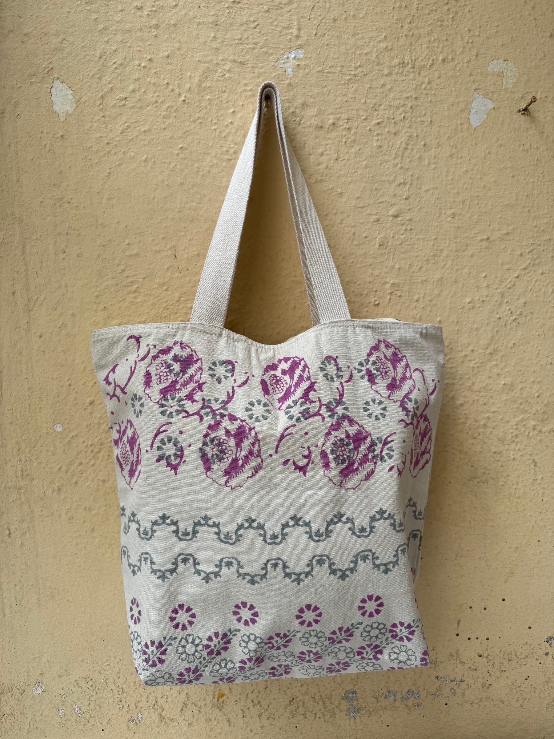 Cotton tote with a woven herringbone panel below a plain cream top, brown handles