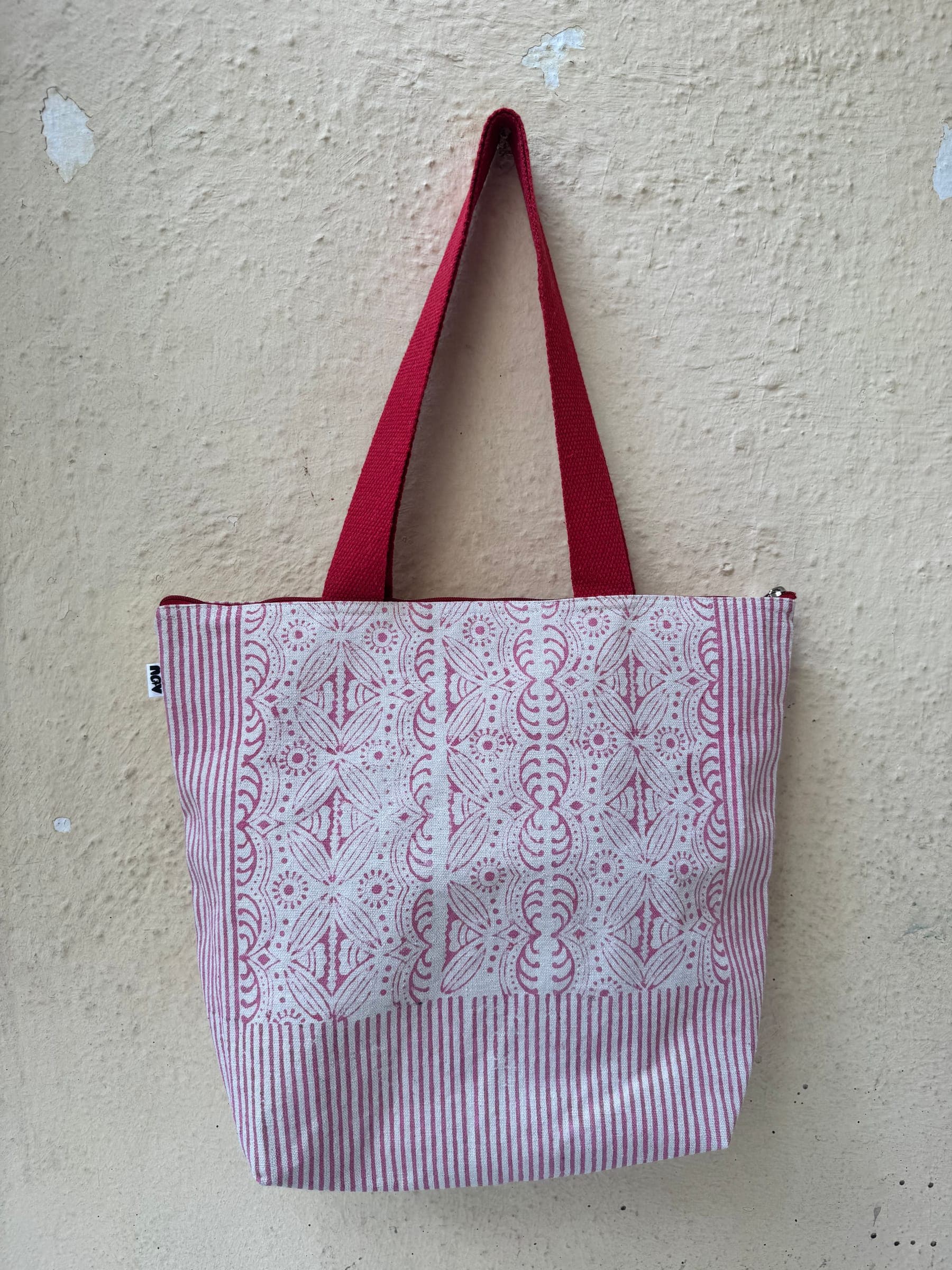 Cotton tote block-printed with pink vines over candy stripes, red handles