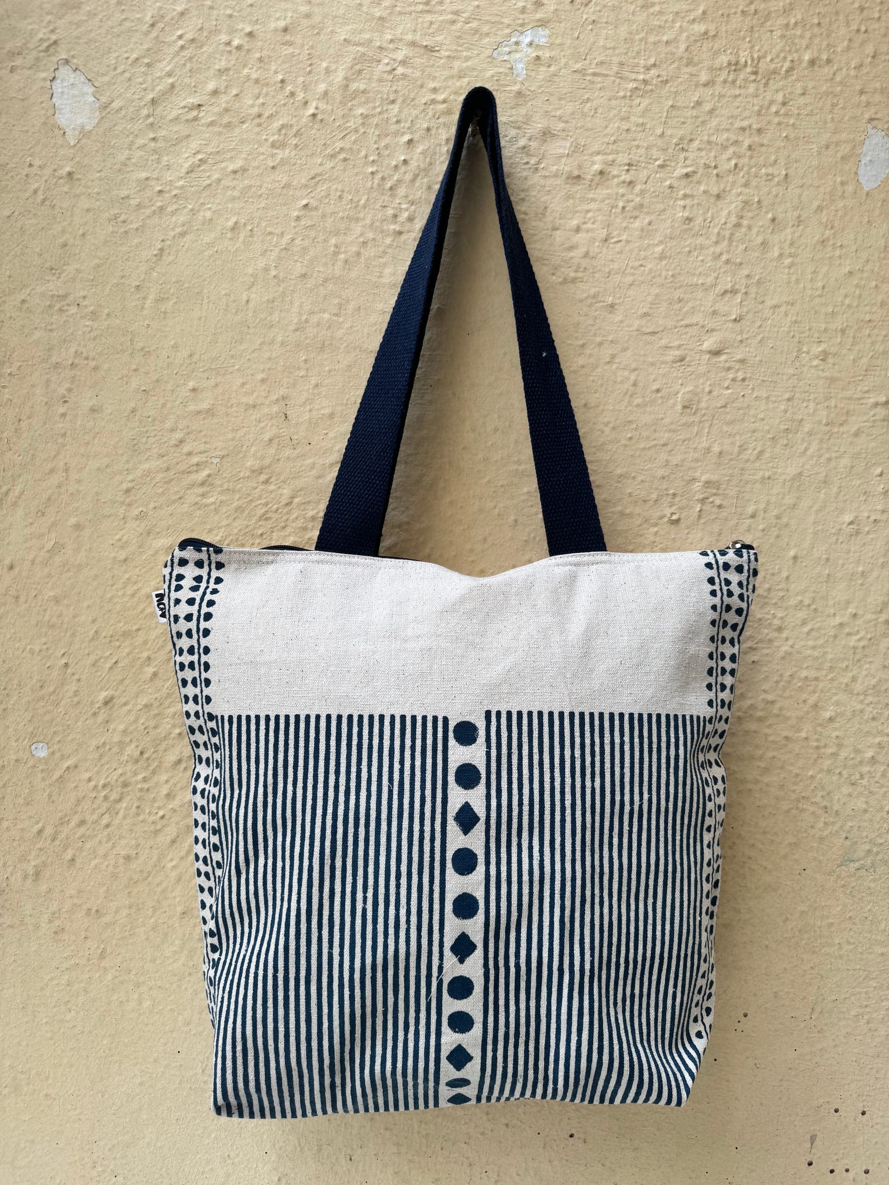 Cotton tote in navy stripes with a column of hand-printed dots, cream top and navy handles