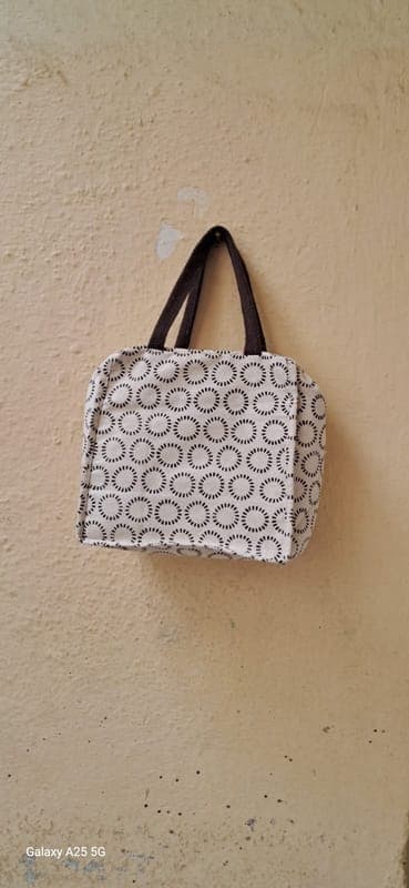 Mini handbag in a grey and white circle block print with short brown handles
