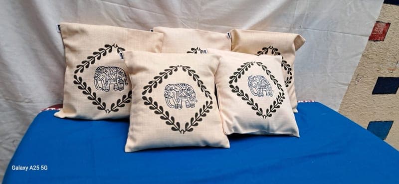 Cream cushion covers block-printed with elephants inside stitched diamond borders