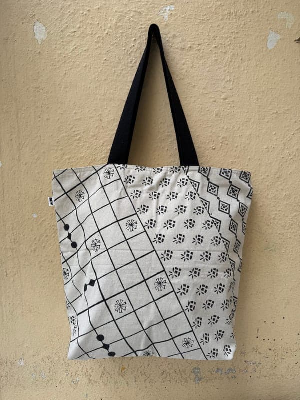 Cotton tote in a black and white patchwork of floral and diamond block prints, black handles